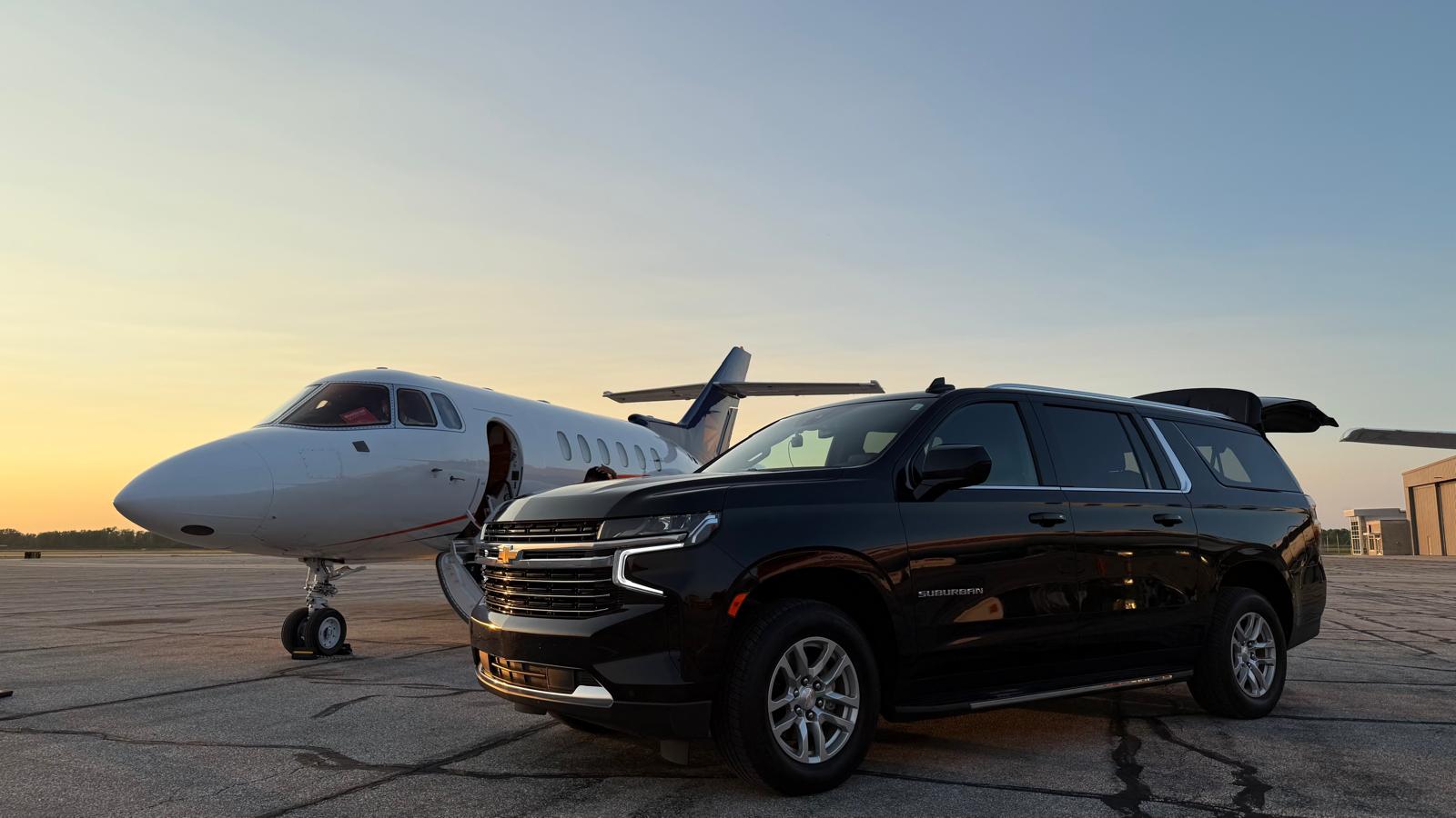 LuxeDetroit SUV beside a private jet